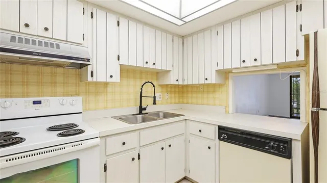a kitchen with stainless steel appliances a sink stove and cabinets