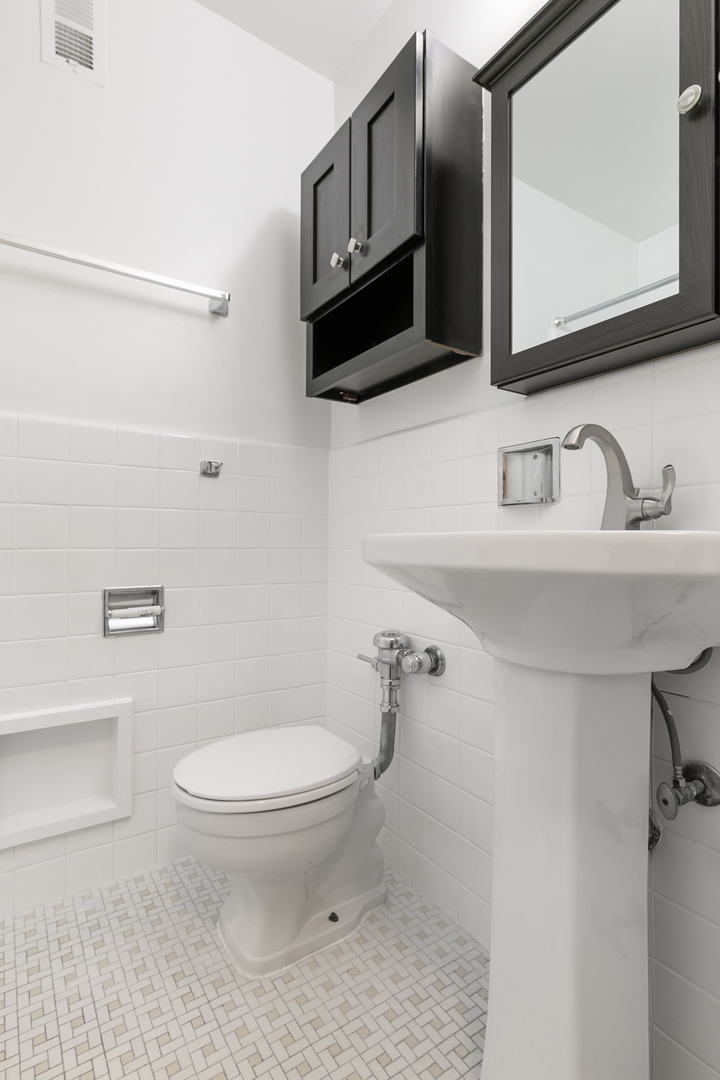 5858 North Sheridan Road, Unit 808 Chicago, IL 60660 - Photo 10 of 16 a bathroom with a sink a toilet and mirror