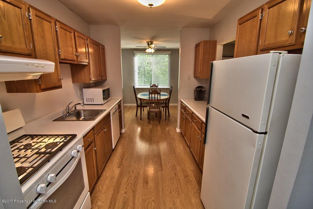 1211 Summit Pointe Scranton, PA 18508 - Photo 4 of 33 a kitchen with sink a refrigerator and wooden cabinets