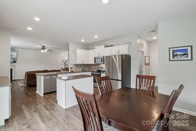 a kitchen with granite countertop white cabinets dining table and chairs