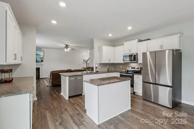 a kitchen with granite countertop a sink stove and refrigerator