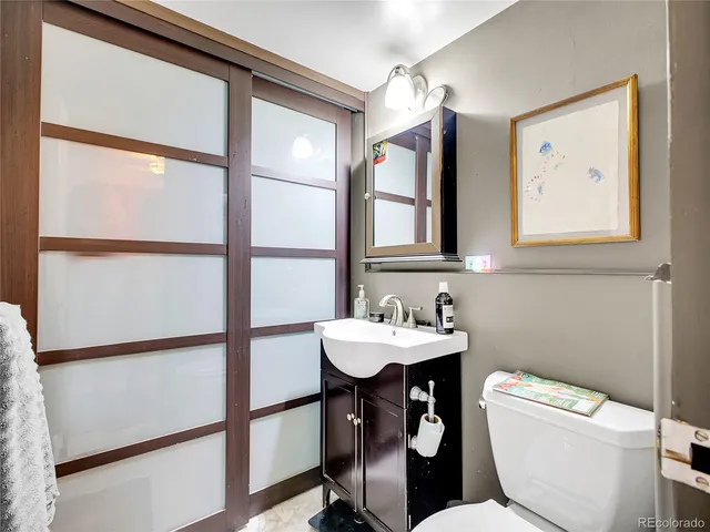 a bathroom with a toilet a sink and a large mirror