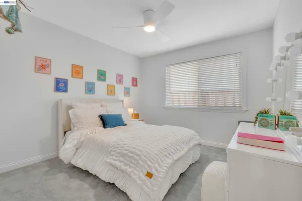 a bedroom with a bed a dresser and a window