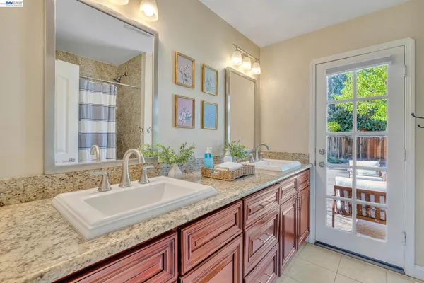 a bathroom with a granite countertop sink and a mirror