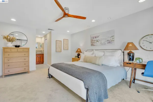 a bedroom with a bed a dresser and chair