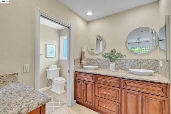 a bathroom with a granite countertop sink and a mirror