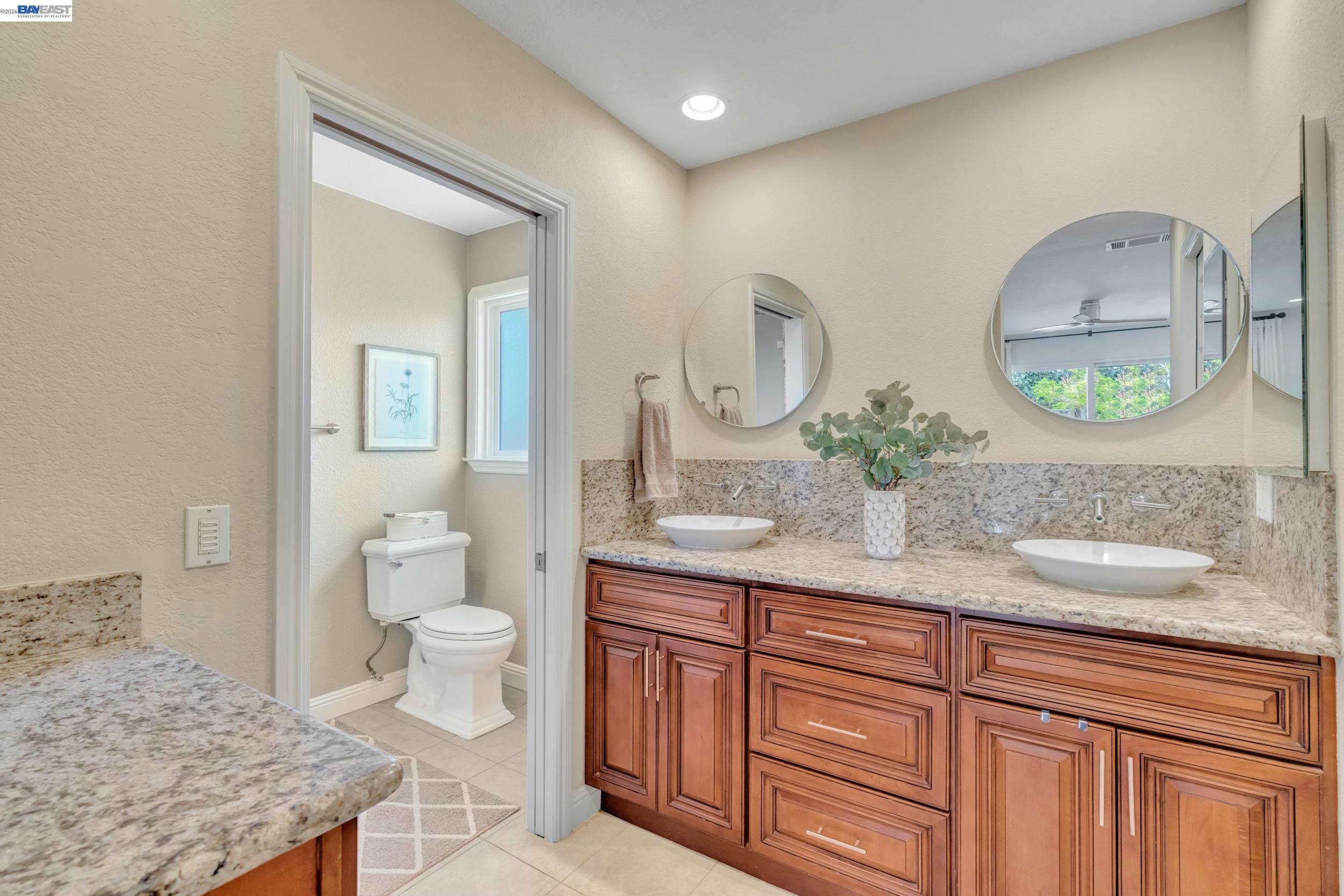 2070 Raven Road Pleasanton, CA 94566 - Photo 20 of 34 a bathroom with a granite countertop sink and a mirror
