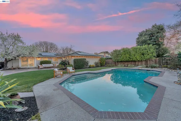 a view of a house with pool and a yard