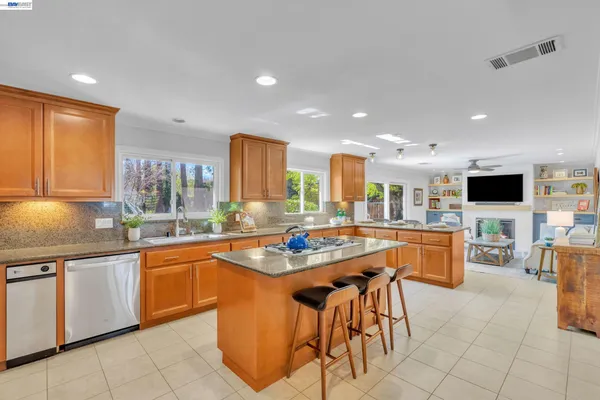 a kitchen with stainless steel appliances kitchen island granite countertop a sink and cabinets