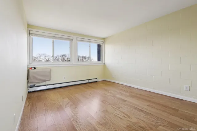 an empty room with wooden floor and window