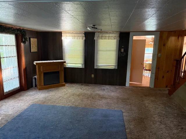 an empty room with windows and fireplace