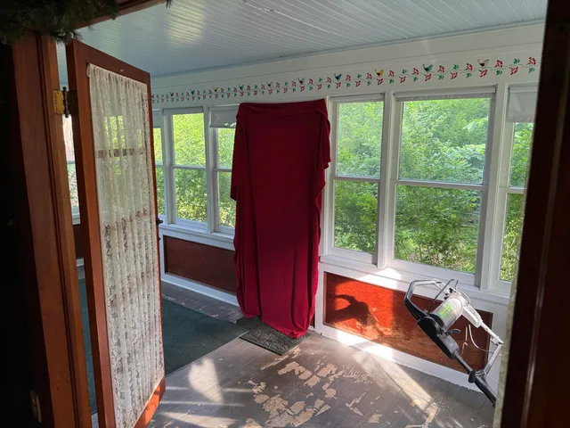 a view of a room with a large window and front door