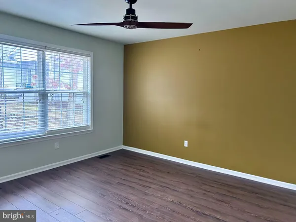 a view of an empty room and a ceiling fan
