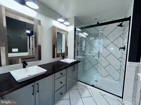 a bathroom with a double vanity sink a mirror and a bathtub