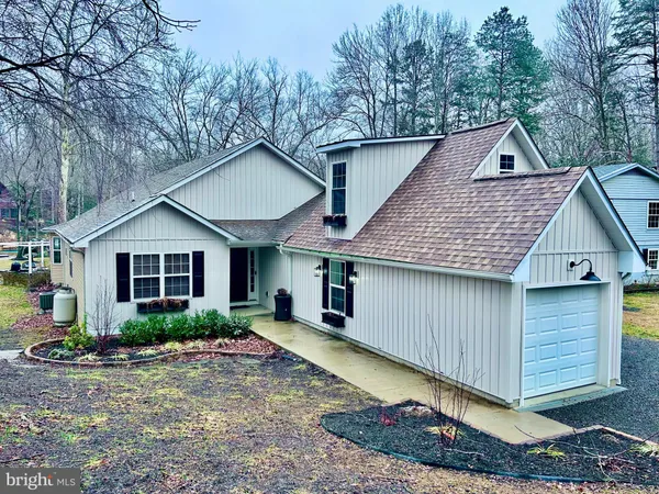 a backyard of a house with large trees and wooden fence