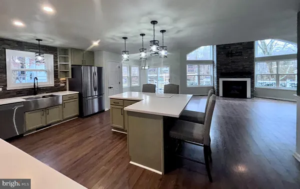 a kitchen with stainless steel appliances a dining table chairs stove and refrigerator