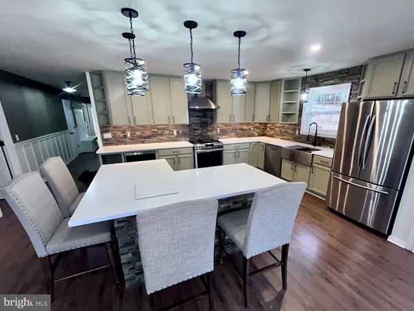 a kitchen with a dining table chairs stainless steel appliances and cabinets