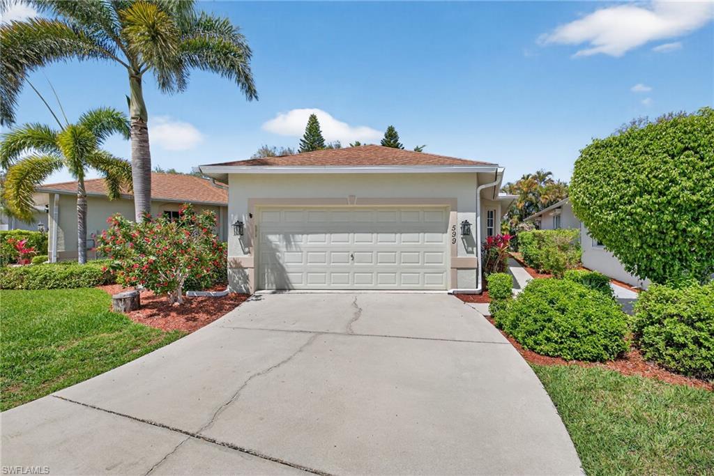 Single story home featuring concrete driveway, an attached garage, stucco siding, and a front yard