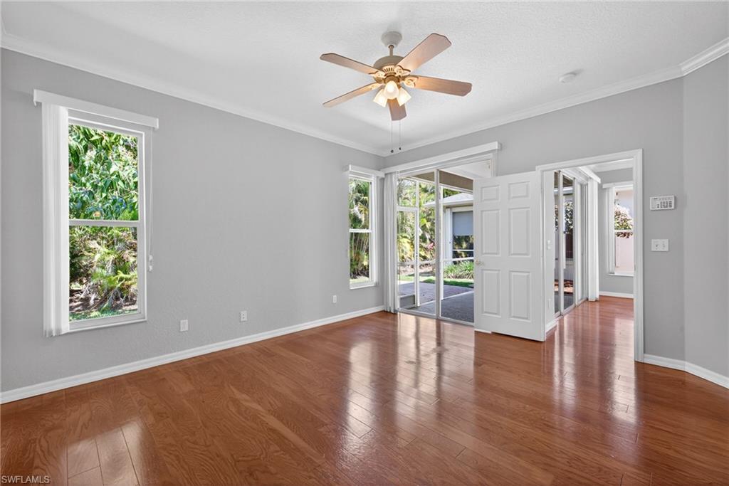 599 Crossfield Circle, Unit 35 Naples, FL 34104 - Photo 15 of 26 Empty room with ceiling fan, ornamental molding, and dark wood-style floors