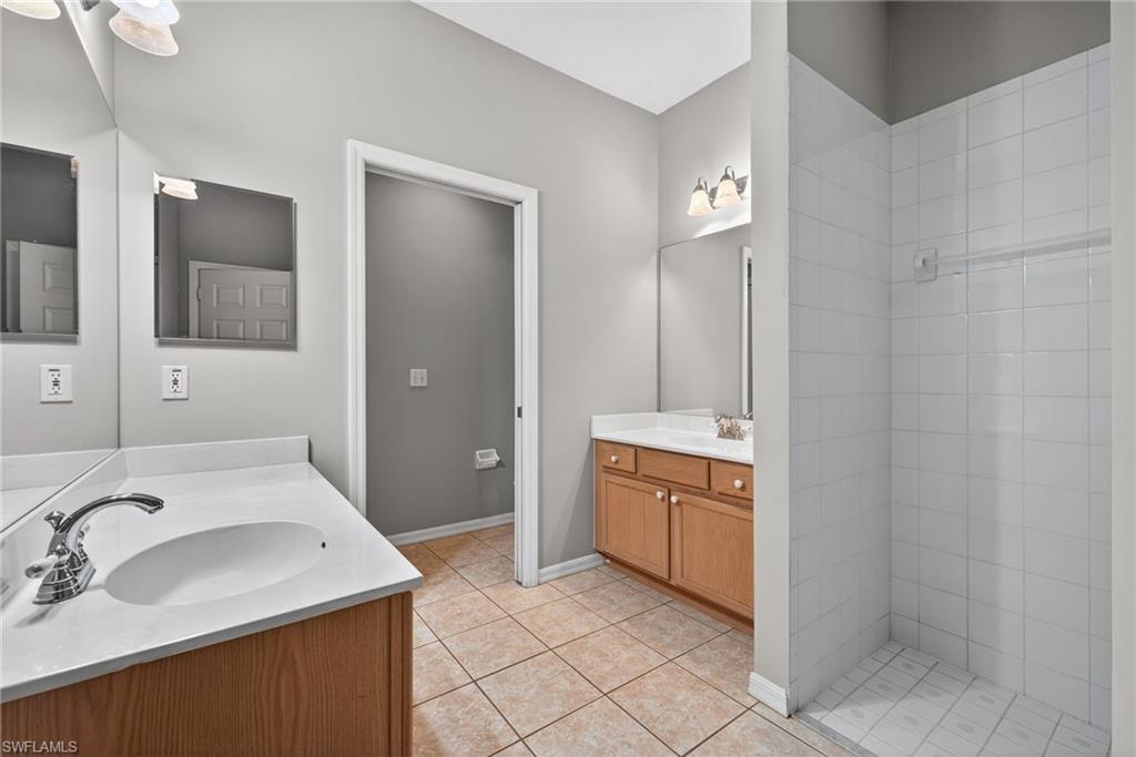 599 Crossfield Circle, Unit 35 Naples, FL 34104 - Photo 17 of 26 Full bathroom featuring two vanities and light tile patterned floors