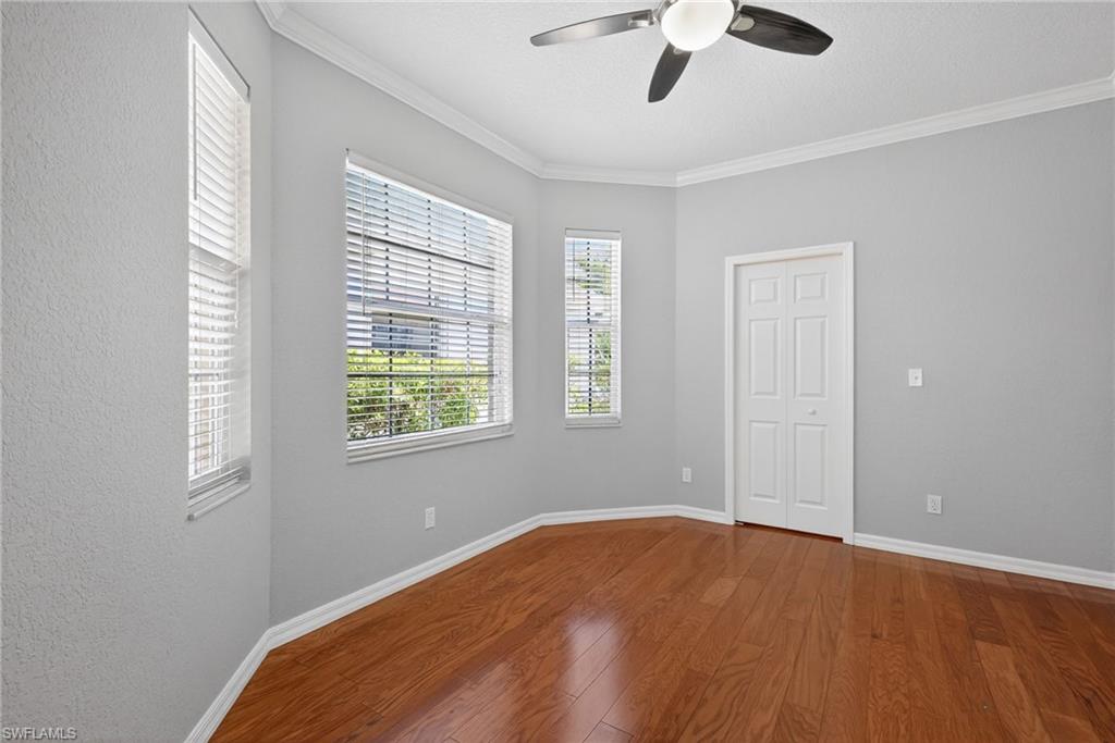 599 Crossfield Circle, Unit 35 Naples, FL 34104 - Photo 19 of 26 Unfurnished room with dark wood-style flooring, a ceiling fan, and ornamental molding