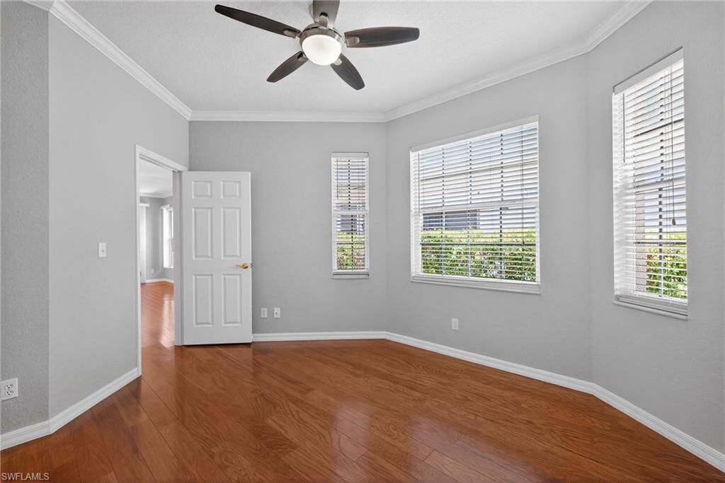 599 Crossfield Circle, Unit 35 Naples, FL 34104 - Photo 20 of 26 Unfurnished bedroom with ornamental molding, a ceiling fan, and dark wood-style floors