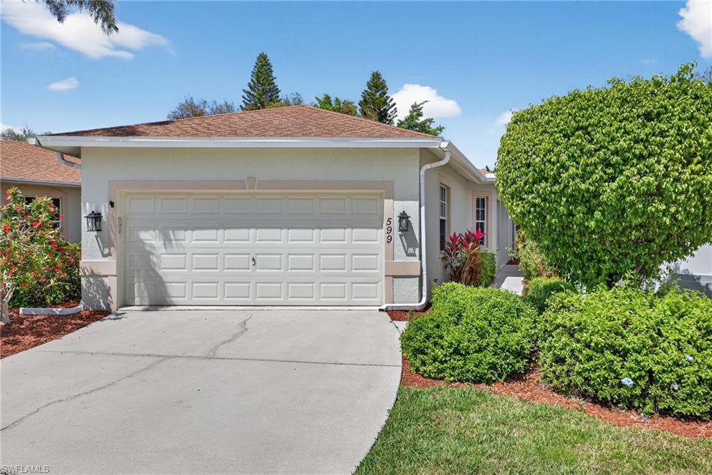 599 Crossfield Circle, Unit 35 Naples, FL 34104 - Photo 2 of 26 Single story home featuring an attached garage, stucco siding, and concrete driveway