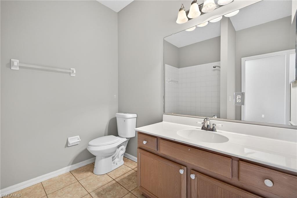 599 Crossfield Circle, Unit 35 Naples, FL 34104 - Photo 21 of 26 Bathroom with vanity, light tile patterned floors, and a shower