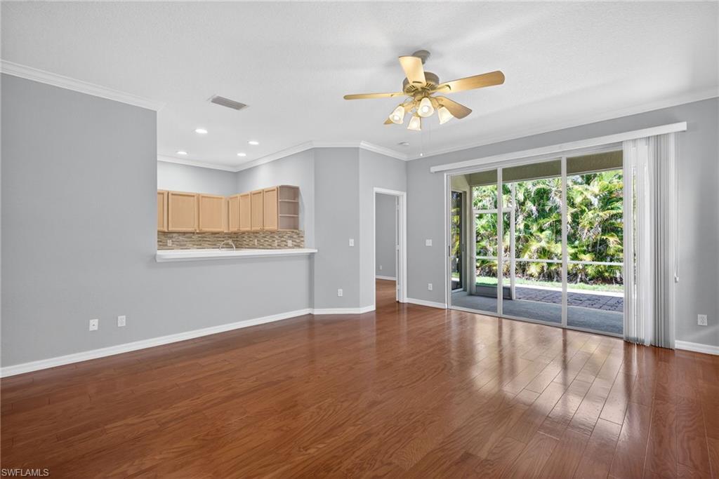 599 Crossfield Circle, Unit 35 Naples, FL 34104 - Photo 5 of 26 Unfurnished living room featuring recessed lighting, ceiling fan, crown molding, and dark wood-type flooring