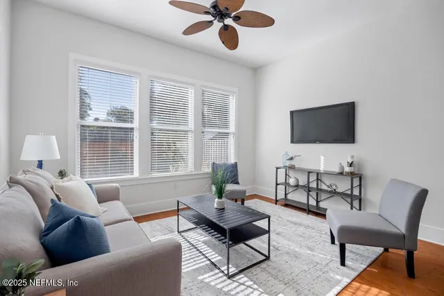 a living room with furniture a window and a flat screen tv
