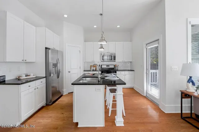 a kitchen with stainless steel appliances granite countertop a stove top oven a refrigerator a sink and a refrigerator