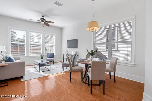 a dining room with furniture a chandelier and wooden floor