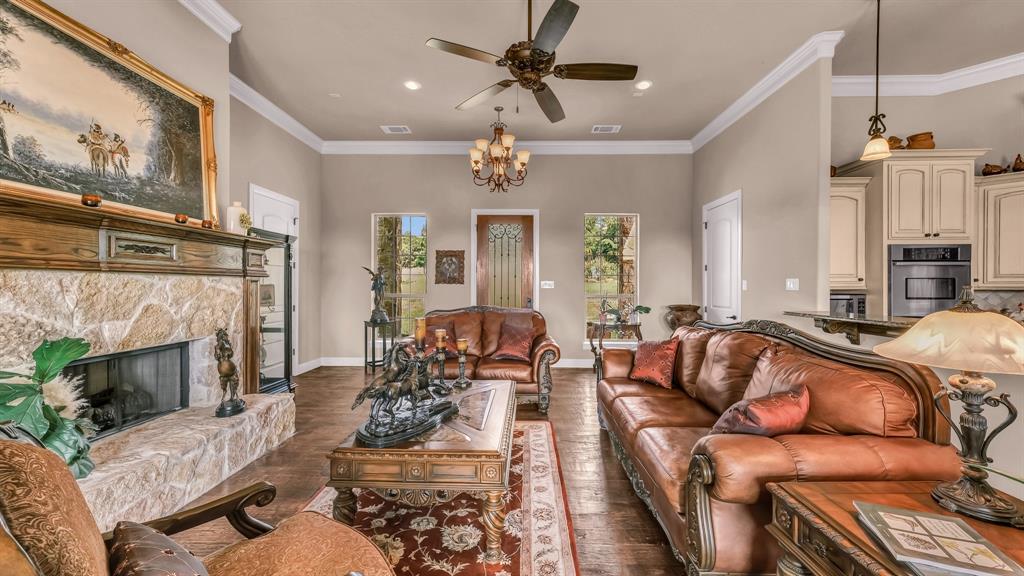 840 Hensley Road Gordon, TX 76453 - Photo 6 of 40 Living area featuring visible vents, dark wood-style floors, ornamental molding, and ceiling fan with notable chandelier