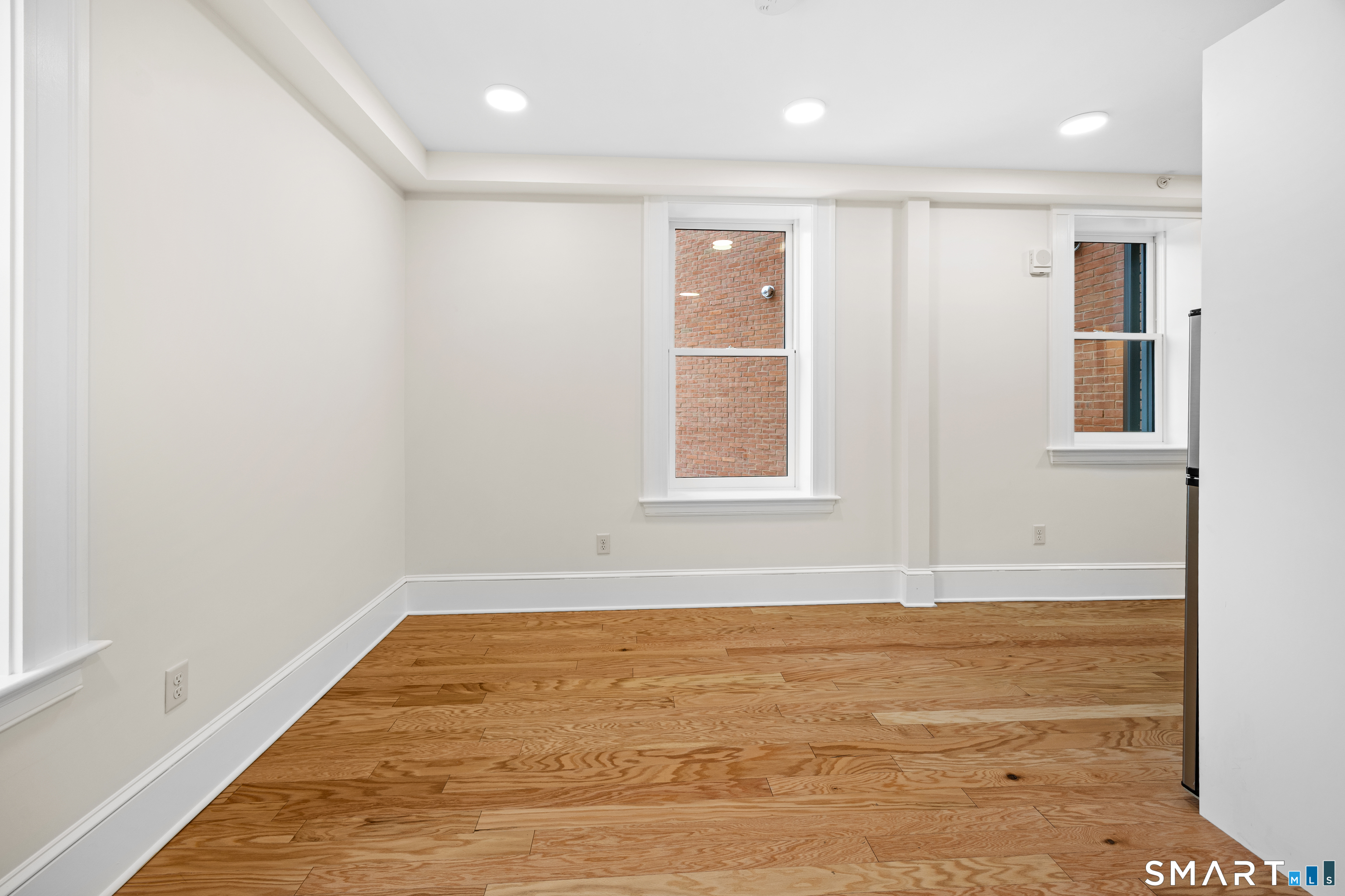 1355 Main Street, Unit 405 Hartford, CT 06103 - Photo 6 of 11 an empty room with wooden floor and windows