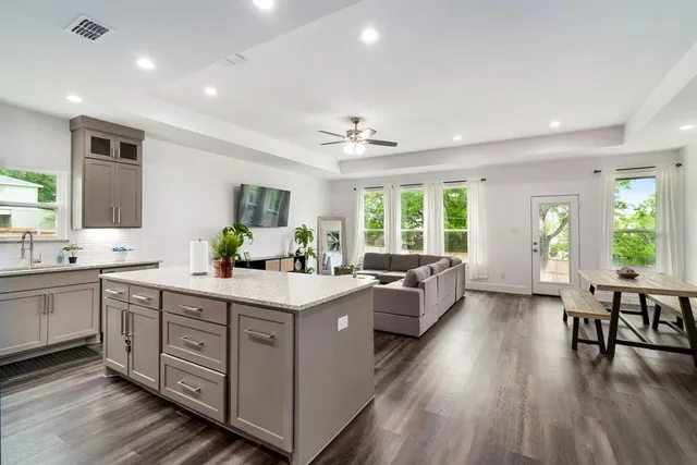 a large white kitchen with a large window and stainless steel appliances