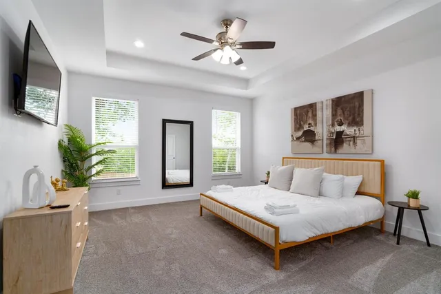 a bedroom with a large bed a flat screen tv and a couch