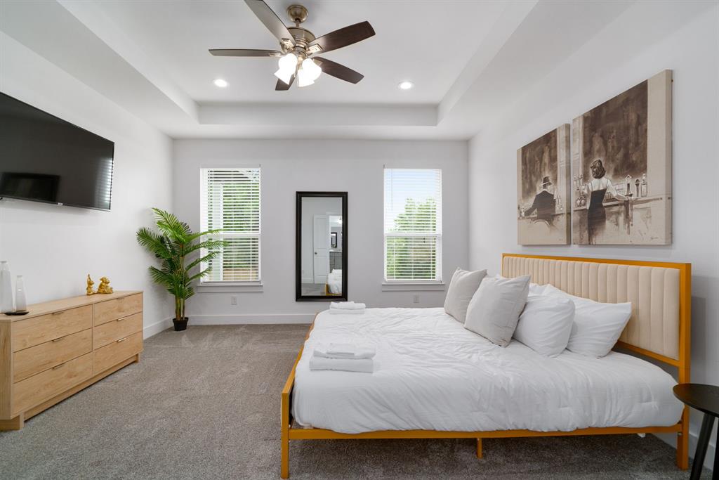 519 High Street Dallas, TX 75203 - Photo 21 of 38 a bedroom with a large bed a flat screen tv and a couch