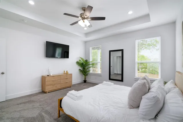 a bedroom with a bed window and a flat screen tv
