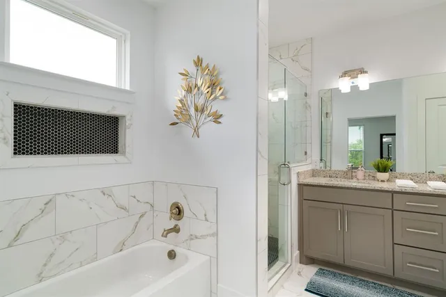 a bathroom with a bathtub sink and mirror