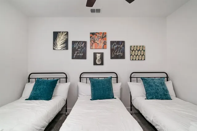 a bedroom with two beds and painting on the wall