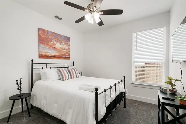 a bed sitting in a bedroom next to a window