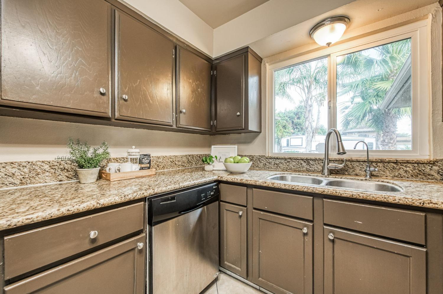 2866 Caesar Avenue Clovis, CA 93612 - Photo 13 of 45 a kitchen with stainless steel appliances granite countertop cabinets sink and window