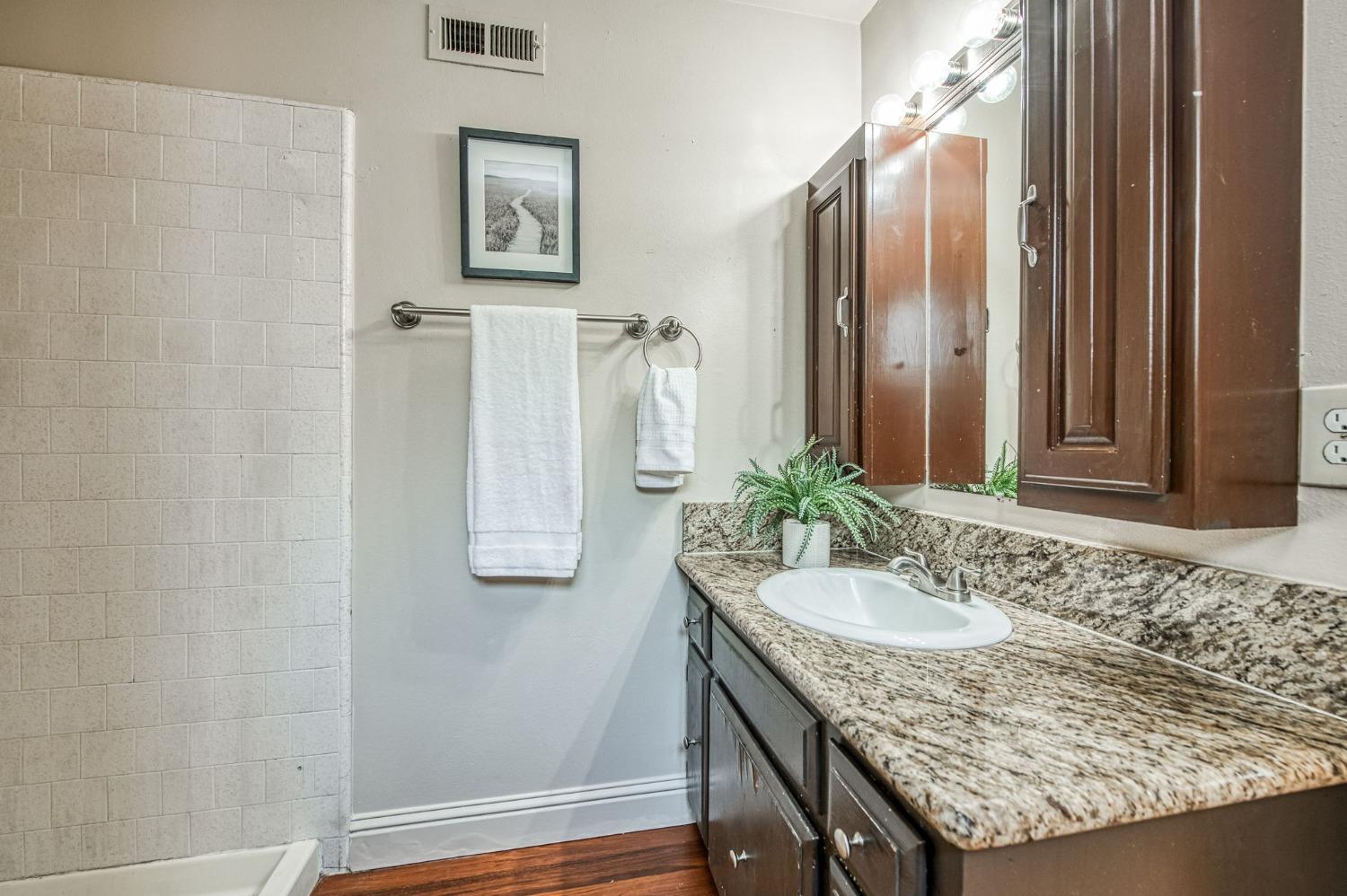 2866 Caesar Avenue Clovis, CA 93612 - Photo 26 of 45 a bathroom with a granite countertop sink and a mirror