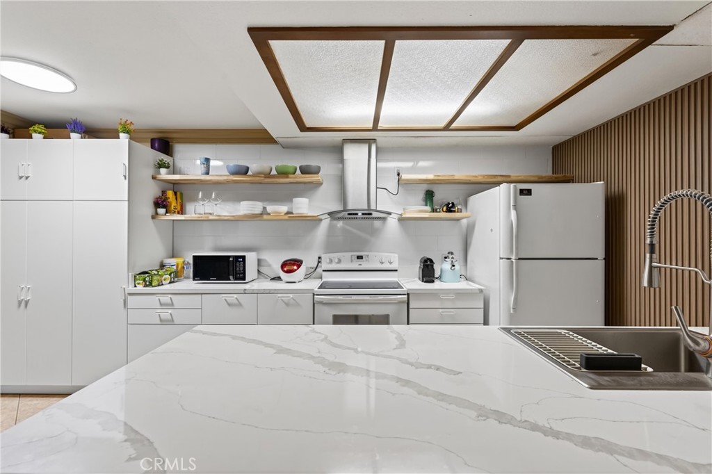 3535 Banbury Drive, Unit 14 Riverside, CA 92505 - Photo 5 of 26 a kitchen with a refrigerator and white cabinets