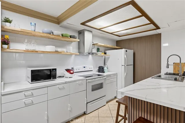 a kitchen with a sink a refrigerator and cabinets