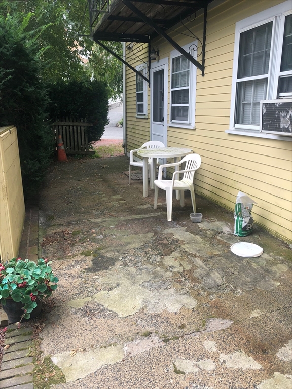 28 Darling Street, Unit 3 Marblehead, MA 01945 - Photo 8 of 8 a backyard of a house with fountain table and chairs