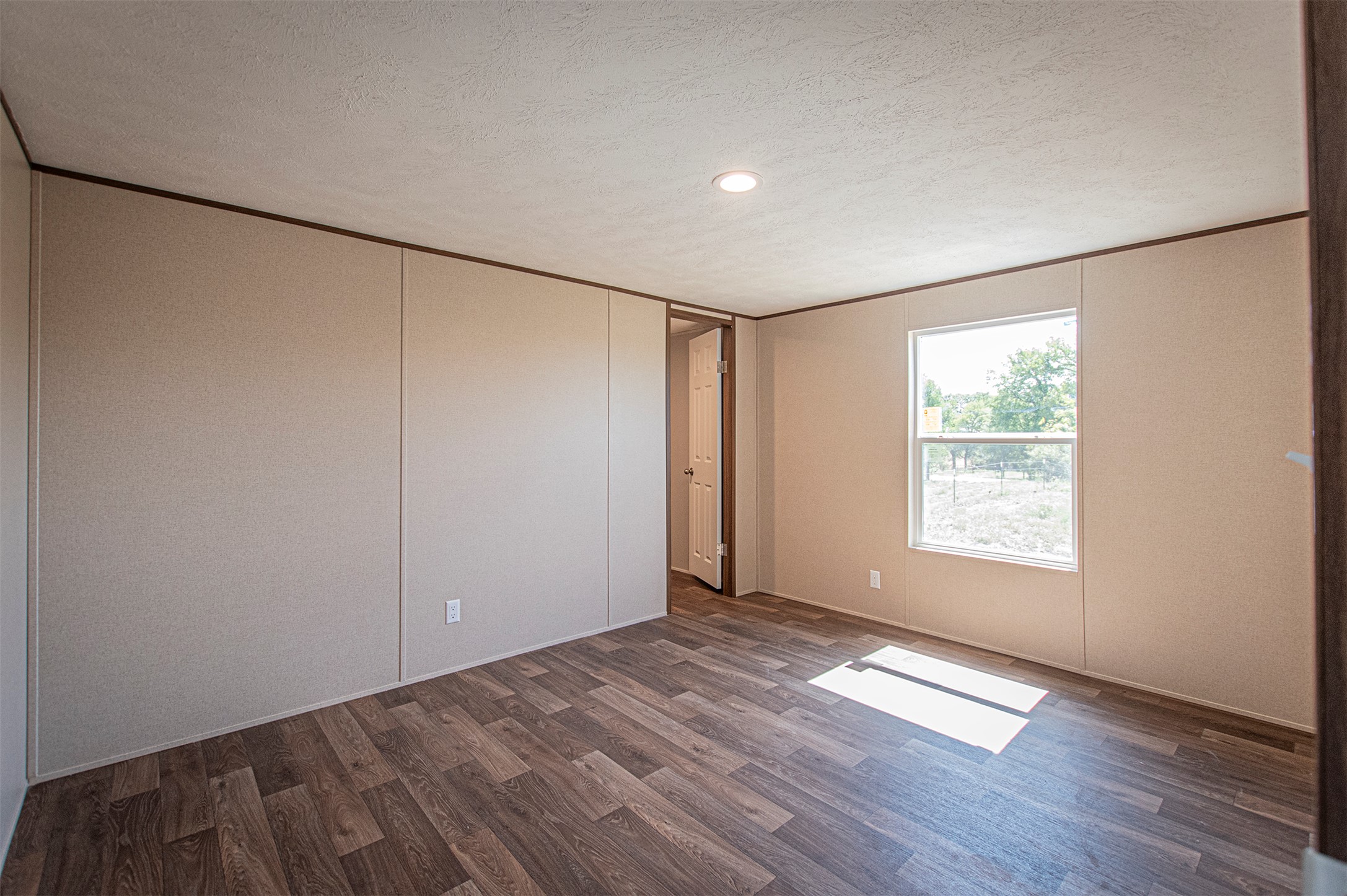 135 Spanish Oak Road Dale, TX 78616 - Photo 19 of 30 a view of an empty room with wooden floor and a window