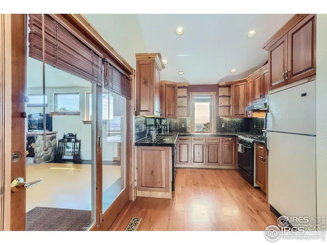 a kitchen with refrigerator cabinets and wooden floor