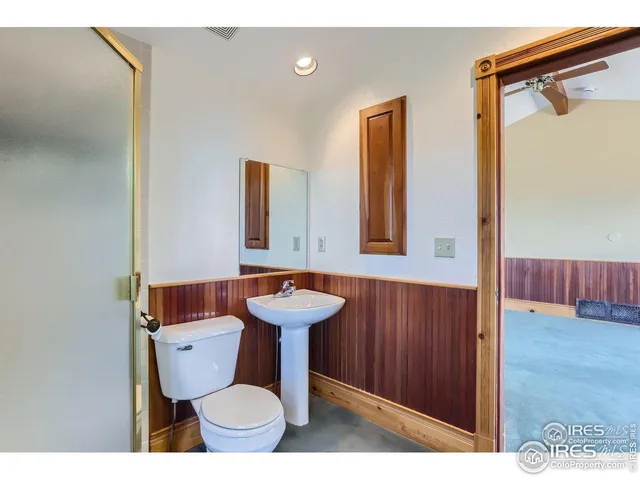 a bathroom with a toilet a sink and mirror
