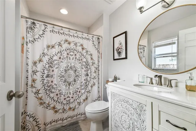 a bathroom with a sink toilet and a mirror